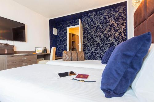 a hotel room with a bed and a tv at Madame Vacances - Hôtel Courchevel Olympic in Courchevel