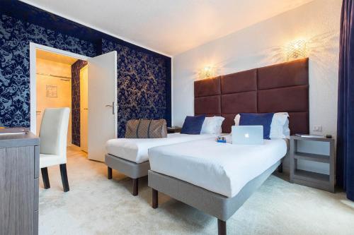 a hotel room with two beds and a laptop on it at Madame Vacances - Hôtel Courchevel Olympic in Courchevel