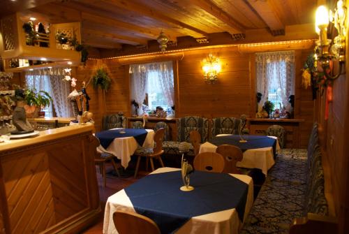 une salle à manger avec deux tables et un bar dans l'établissement Albergo Genziana, à San Vigilio Di Marebbe