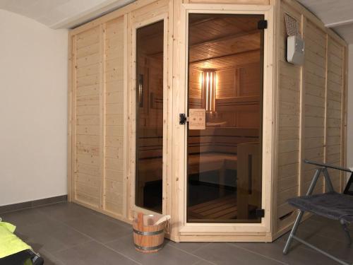 a room with a wooden wall with a glass door at FeWo Bettenhausen in Morschen