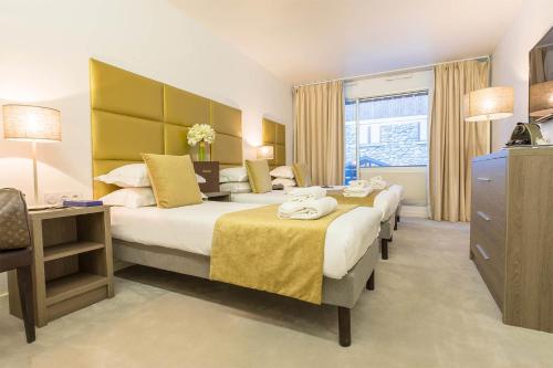 a hotel room with two beds and a window at Madame Vacances - Hôtel Courchevel Olympic in Courchevel