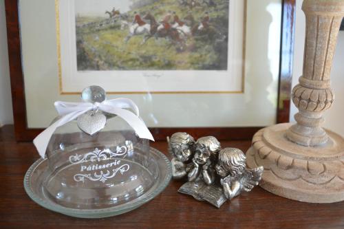 a table topped with a silver plate with two figurines at Maison Durbuy L'air du temps in Weris