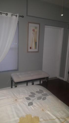 a bed with a bench in a room with a window at Perfect Business Penthouse 3BR Near NYC in Union City