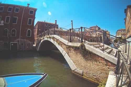 a bridge over a canal with a boat in the water at La Serenissima - 15 min to Venice City Center - Free Parking in Campalto