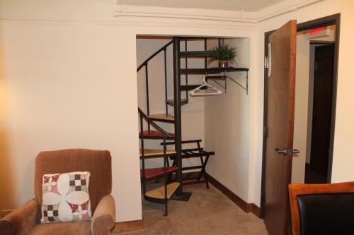 a spiral staircase in a living room with a chair at Iowa House Historic Inn in Ames