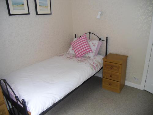 a small bed with two pillows and a night stand at Ormidale Hotel in Brodick