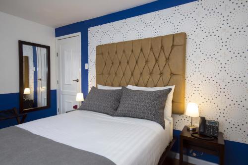 a bedroom with a large bed with a blue headboard at TERRA PREMIUM Hostal Boutique in Quito