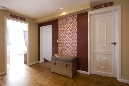 a hallway with a door and a ottoman in a room at TERRA PREMIUM Hostal Boutique in Quito