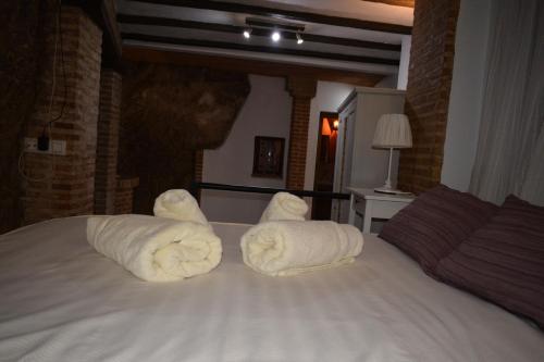 a bed with white towels on top of it at Casa Cueva El Pocito in Peñaflor