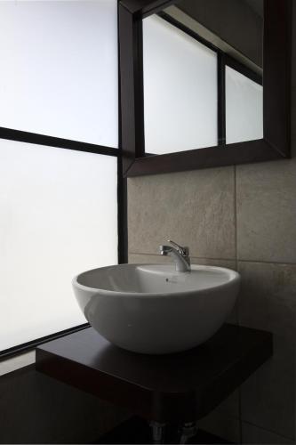 a white sink in a bathroom with two windows at TERRA PREMIUM Hostal Boutique in Quito