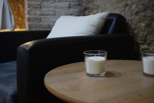 a glass of milk sitting on a table next to a couch at Casa Cueva El Pocito in Peñaflor