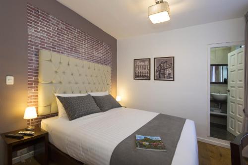 a bedroom with a large bed and a brick wall at TERRA PREMIUM Hostal Boutique in Quito
