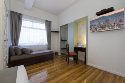 sala de estar con sofá y escritorio en TERRA PREMIUM Hostal Boutique, en Quito