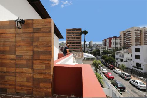 a man standing on the balcony of a building at TERRA PREMIUM Hostal Boutique in Quito