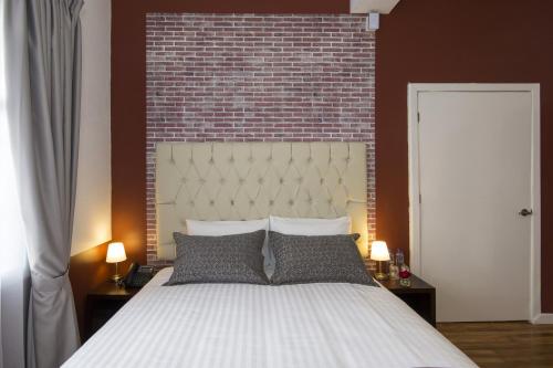 a bedroom with a large bed with a brick wall at TERRA PREMIUM Hostal Boutique in Quito