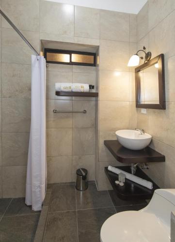 a bathroom with a sink and a toilet and a mirror at TERRA PREMIUM Hostal Boutique in Quito