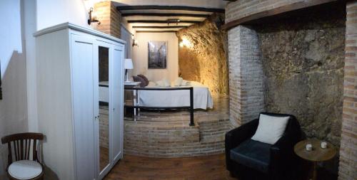 PeñaflorにあるCasa Cueva El Pocitoのベッド、テーブル、椅子が備わる客室です。