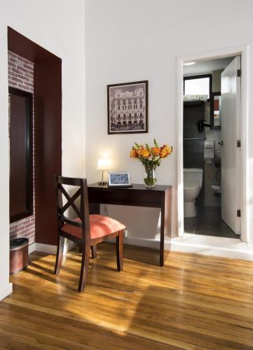 a room with a desk with a vase of flowers at TERRA PREMIUM Hostal Boutique in Quito