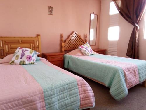 a bedroom with two beds with pillows at Fresnos Residencia Queretaro - in Querétaro