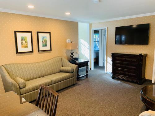 a living room filled with furniture and a tv at Franciscan Inn & Suites in Santa Barbara