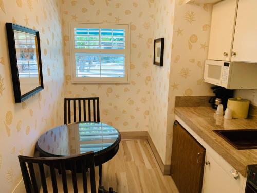a small kitchen with a glass table and a window at Franciscan Inn & Suites in Santa Barbara