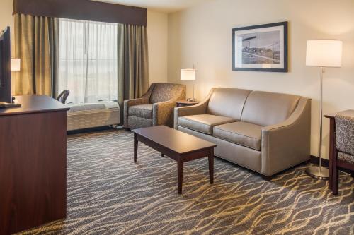 a hotel room with a couch and a chair at Cobblestone Inn and Suites - Ashland in Ashland