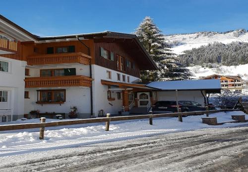 a building with a car parked in the snow at Landhaus Thaler in Mittelberg