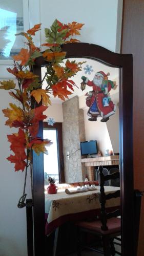 a mirror in a room with a tree with autumn leaves at Elatos cozy Studio in Ano Trikala