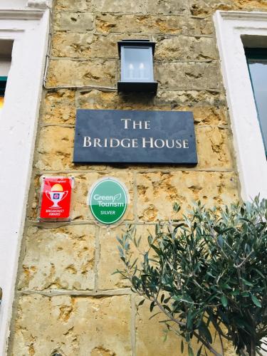 a sign for the bridge house on a stone wall at The Bridge House in Bridport