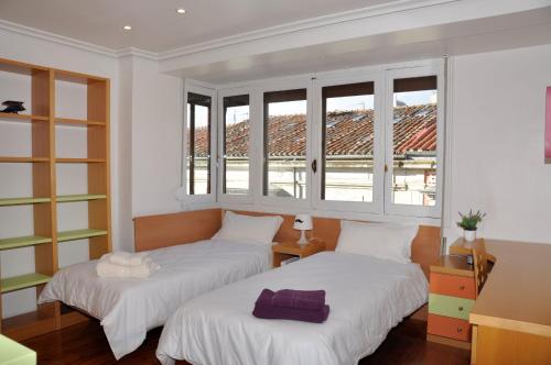 - 2 lits dans une chambre avec 2 fenêtres dans l'établissement VillaDel Casa Urbana, à Burgos