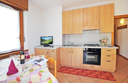 a kitchen with wooden cabinets and a table and a television at Casa Viola Dependance in Valdidentro
