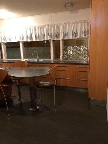 eine Küche mit einem Tisch, Stühlen und einem Waschbecken in der Unterkunft Sæból/Ocean Lair 2 in Grundarfjörður
