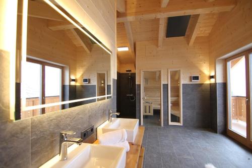 a bathroom with two sinks and a large mirror at Heidi Chalets Falkert Heidialm - Chalet Almsommer in Patergassen