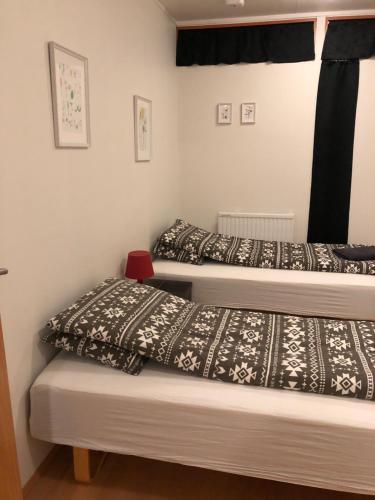2 Betten in einem kleinen Zimmer mit schwarzen und weißen Decken in der Unterkunft Sæból/Ocean Lair 2 in Grundarfjörður