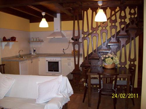 a room with a kitchen with a table and a kitchen at Apartamentos rurales La Lastra 2 llaves, in Caso