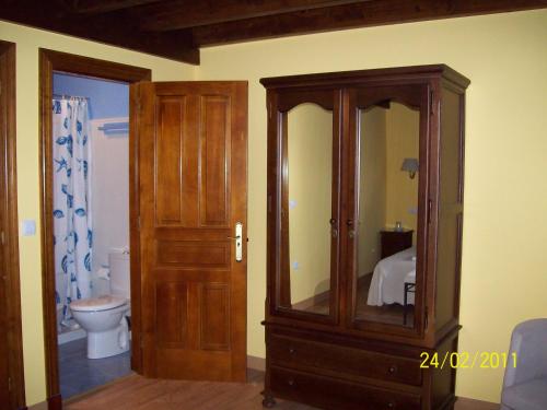 a bathroom with a wooden cabinet and a toilet at Apartamentos rurales La Lastra 2 llaves, in Caso
