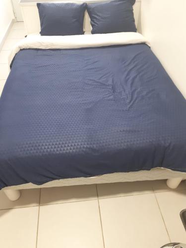 Una cama con un edredón azul. en studio climatisé, en Aviñón