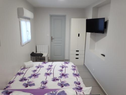 - une chambre avec un lit orné de fleurs violettes dans l'établissement studio climatisé, à Avignon