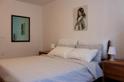una camera con un letto e due quadri appesi al muro di Trentino Apartments - Casa Corn a Folgaria