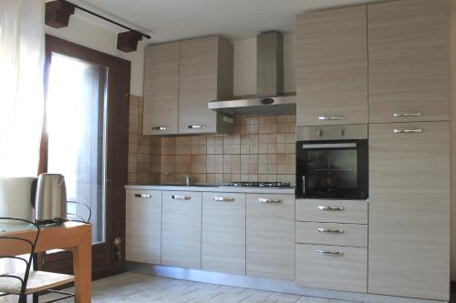 una cucina con armadi in legno e piano cottura di Trentino Apartments - Casa Corn a Folgaria