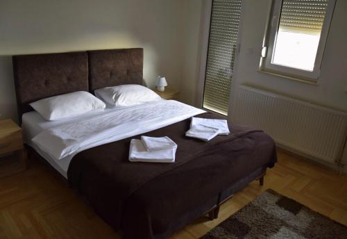 a bedroom with a bed with two towels on it at Apartmani Marić in Novi Pazar