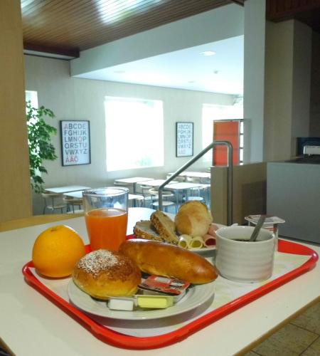 ein Tablett mit Bagels und Orangensaft auf dem Tisch in der Unterkunft Hotel Gameiro in Entroncamento