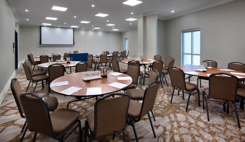 a conference room with tables and chairs and a projection screen at The Novotel Toronto Centre in Toronto