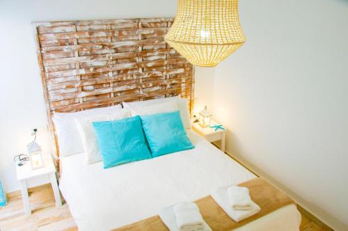 a bedroom with a white bed with blue pillows at Casa Ada 2 in Famara