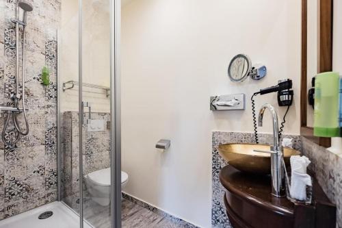 a bathroom with a sink and a shower at HOTEL DÜNENLÄUFER Langeoog in Langeoog