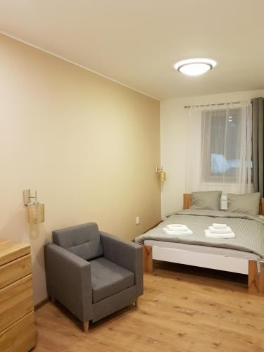 a bedroom with a bed and a chair at Apartmány Pec pod Sněžkou in Pec pod Sněžkou