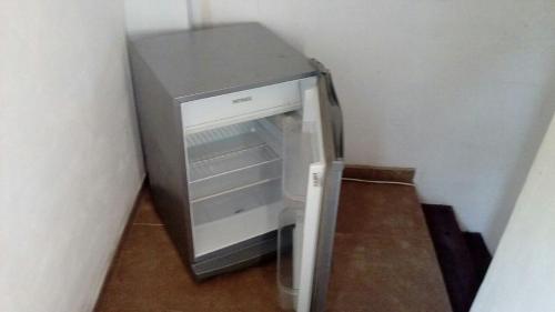 a small refrigerator with its door open in a room at La casita de Pablo in Santa Teresita