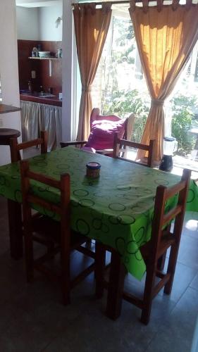 a green table and chairs in a living room at La casita de Pablo in Santa Teresita