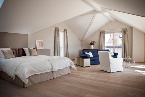1 dormitorio blanco con 1 cama y 2 sillas en Le Coq Chantant Studios d'Hôtes & Boutique Hôtel St-Livres, en Saint-Livres