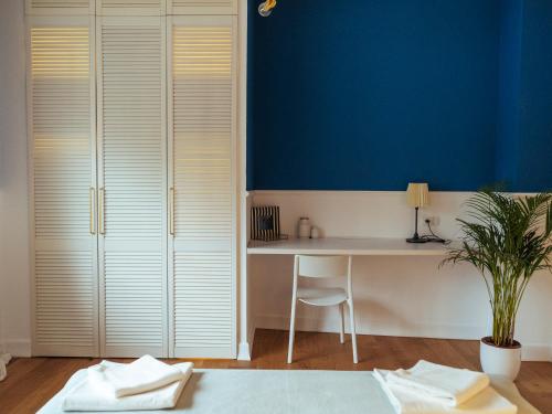 a room with a desk and a blue wall at Boutique Luxury Flats - La Casa di Dolce Vita in Bucharest